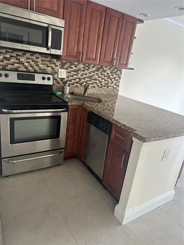 a kitchen with granite countertop a stove and a microwave