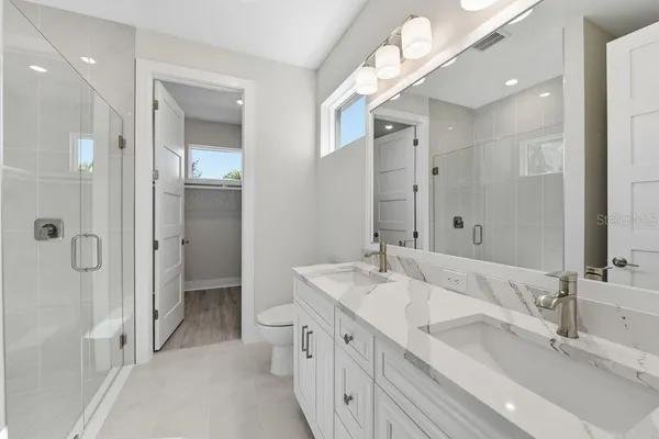 a bathroom with a double vanity sink mirror double and shower