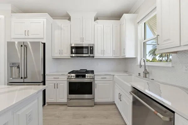 a kitchen with stainless steel appliances granite countertop a stove a sink and a refrigerator