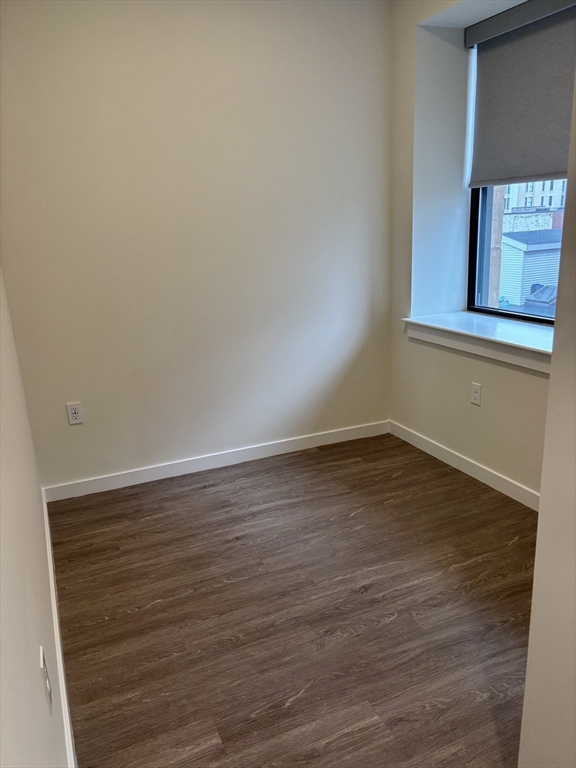 47 Winter Street, Unit 601 Boston, MA 02108 - Photo 8 of 12 a view of an empty room with wooden floor and cabinet