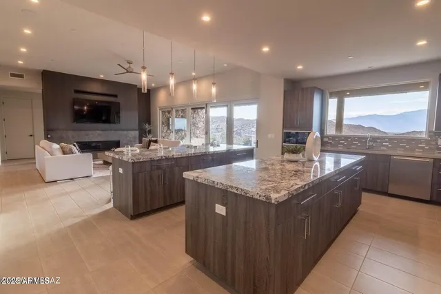 a large kitchen with a large counter top and stainless steel appliances