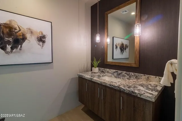 a bathroom with a granite countertop sink and a mirror