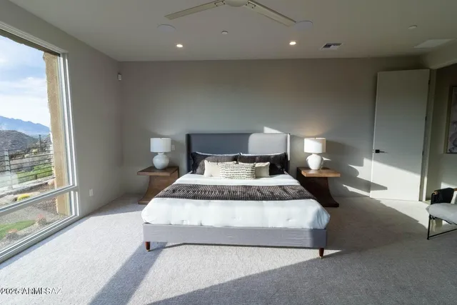 a spacious bedroom with a large bed and a night stand