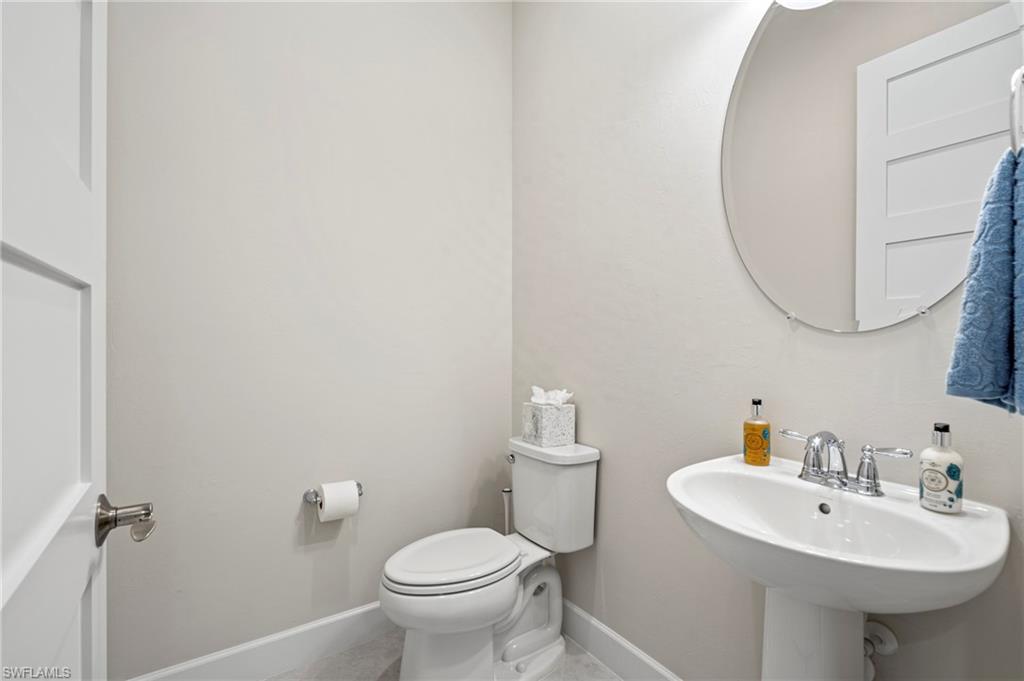 8795 Calypso Court Naples, FL 34113 - Photo 21 of 49 a bathroom with a sink a toilet and mirror