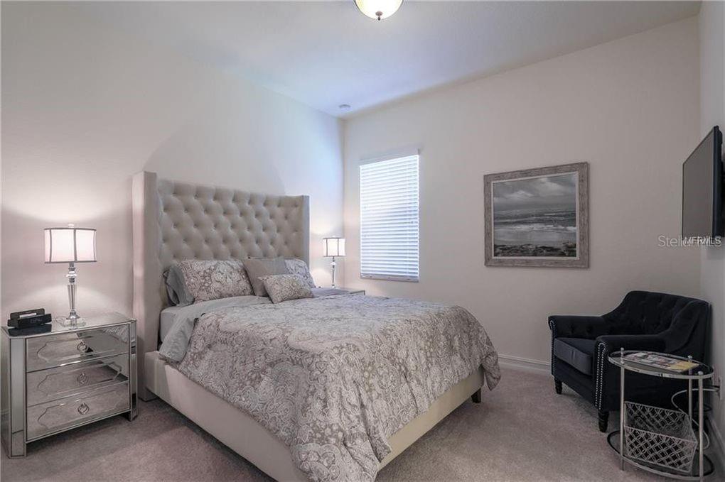 5528 Arnie Loop Lakewood Ranch, FL 34211 - Photo 28 of 59 a bedroom with a bed and a lamp with window