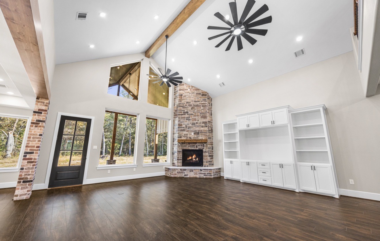 41 A Pausel Road Huntsville, TX 77340 - Photo 11 of 34 an empty room with wooden floor fire place and windows
