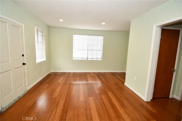 a view of a hallway with wooden floor and closet area