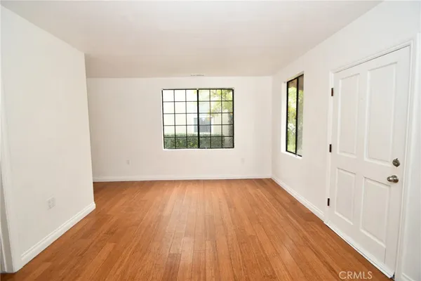 a kitchen with a sink a stove cabinets and wooden floor