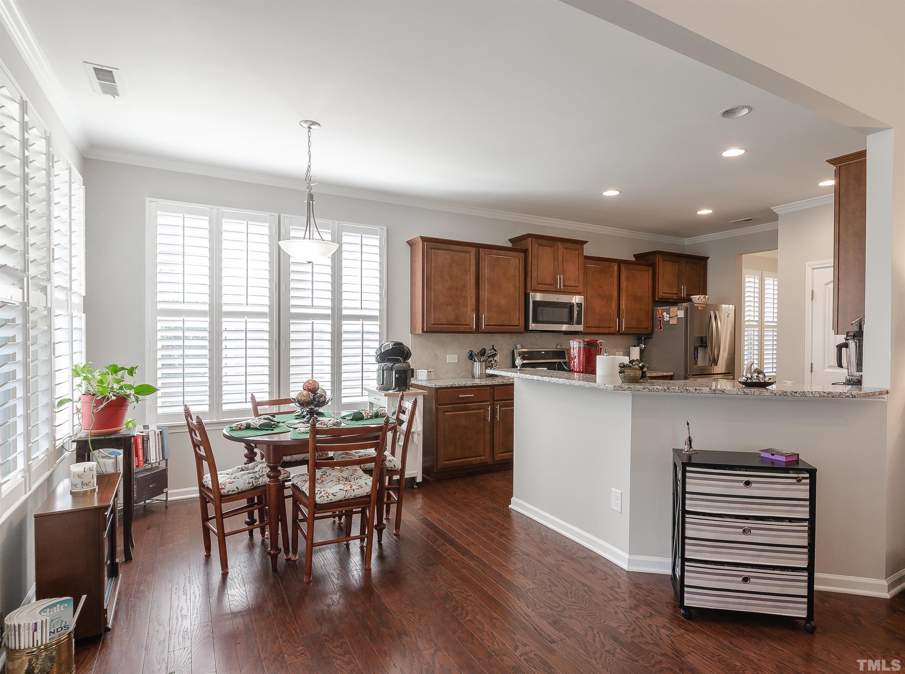1104 Big Spring Circle Durham, NC 27703 - Photo 18 of 47 a kitchen with a table chairs microwave and cabinets