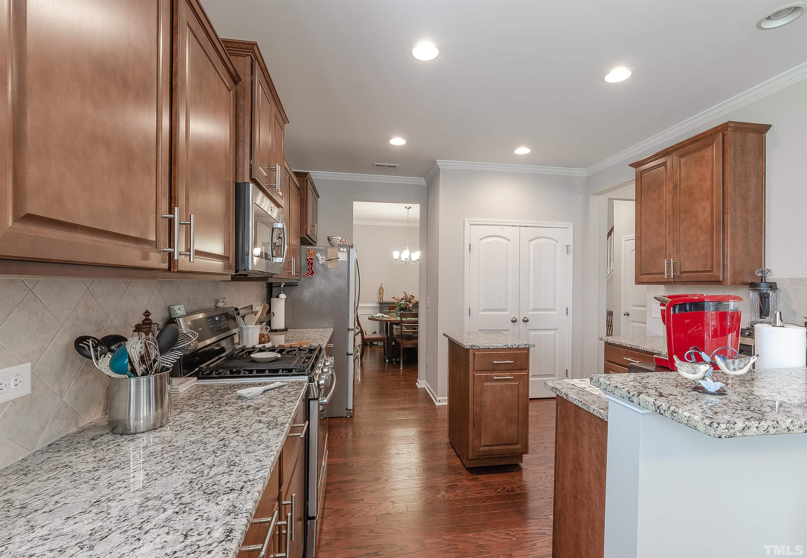 1104 Big Spring Circle Durham, NC 27703 - Photo 20 of 47 a kitchen with stainless steel appliances granite countertop a sink dishwasher and a refrigerator with wooden floor