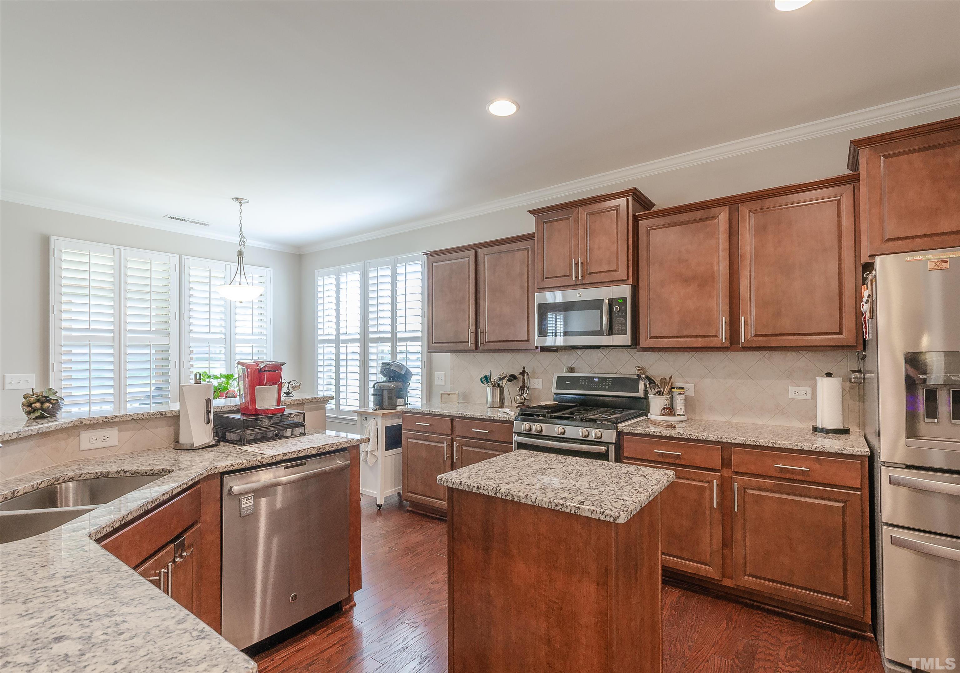 1104 Big Spring Circle Durham, NC 27703 - Photo 21 of 47 a kitchen with stainless steel appliances granite countertop a stove top oven a sink dishwasher a refrigerator and white cabinets with wooden floor