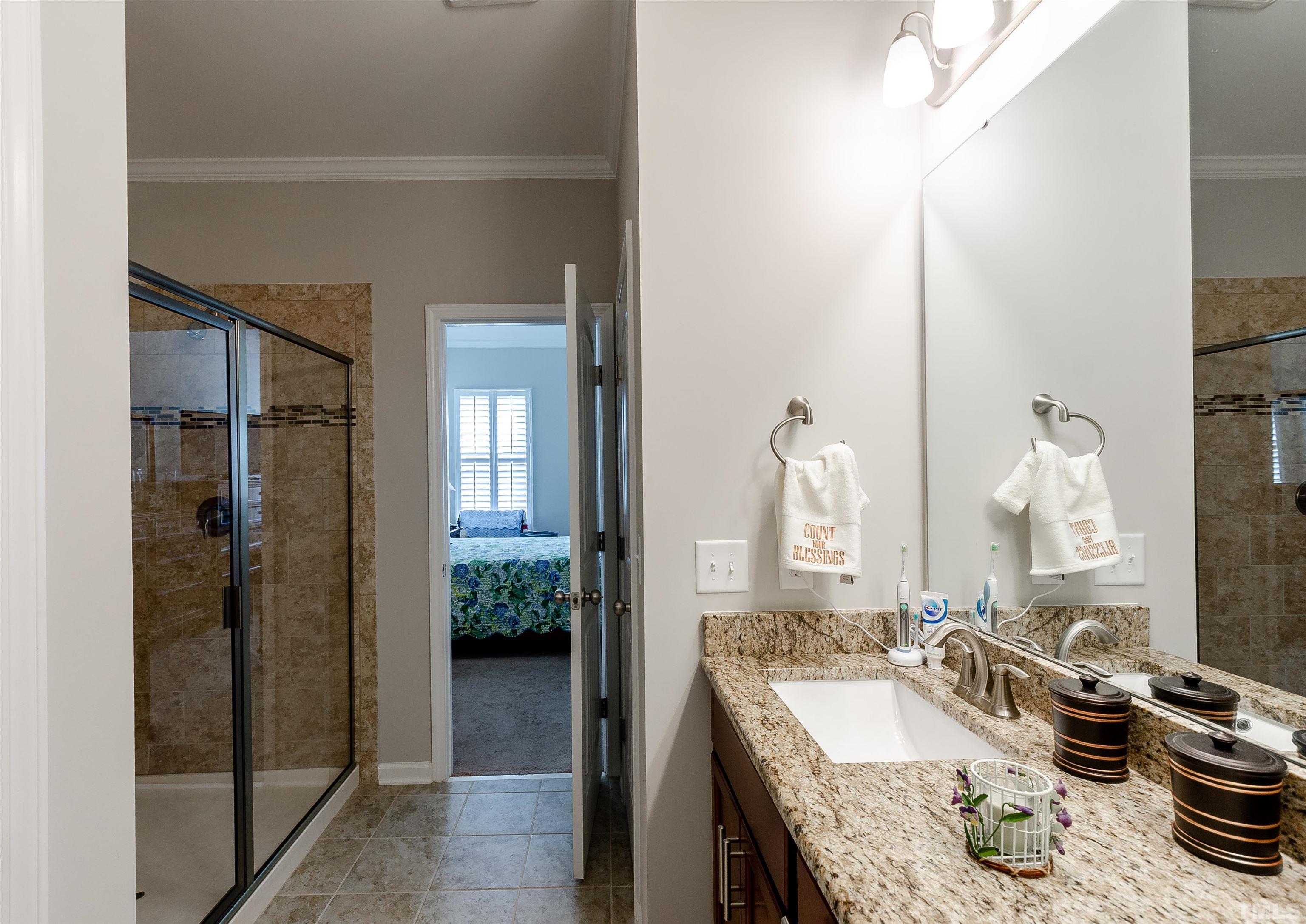 1104 Big Spring Circle Durham, NC 27703 - Photo 27 of 47 a en suite bathroom with a granite countertop sink and a mirror