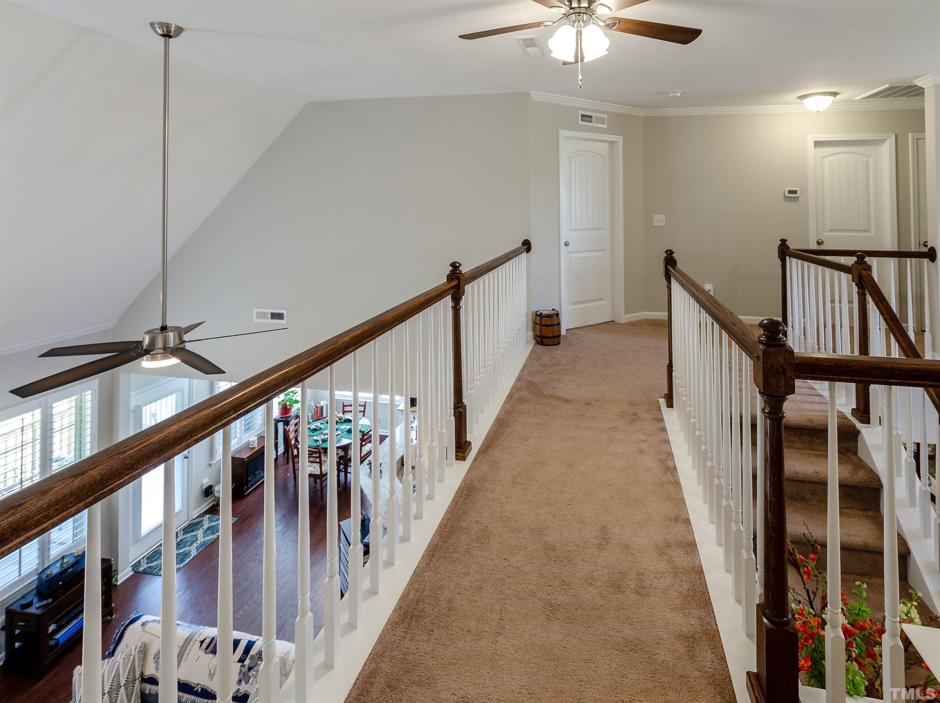 1104 Big Spring Circle Durham, NC 27703 - Photo 32 of 47 a view of staircase with lots of frames on wall and wooden floor