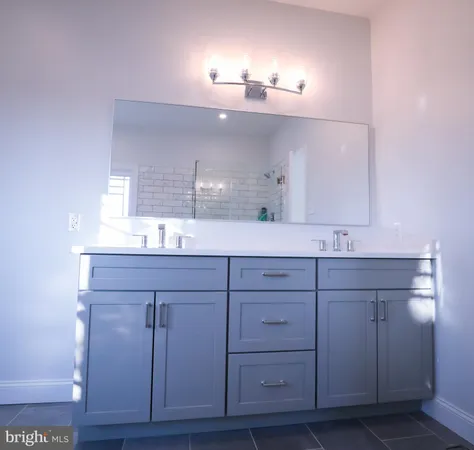 a bathroom with a sink vanity and mirror
