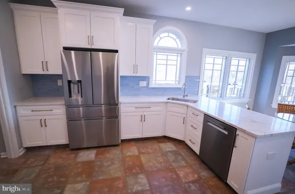 a kitchen with a refrigerator sink and cabinets
