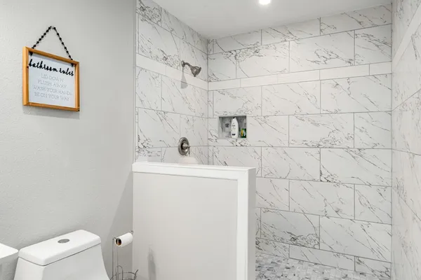 a bathroom with a sink a toilet and shower