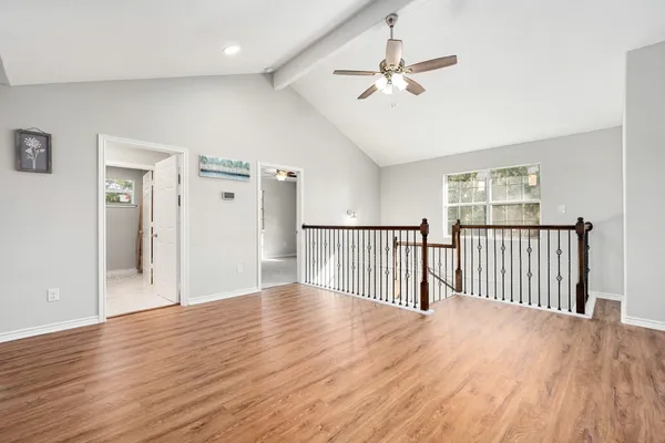 a view of a livingroom with wooden floor and a ceiling fan