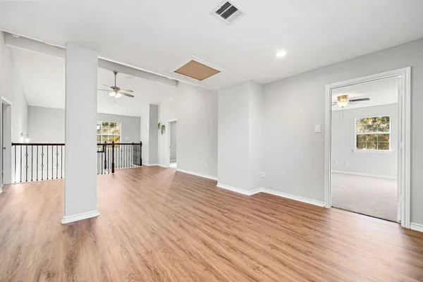 a view of empty room with wooden floor