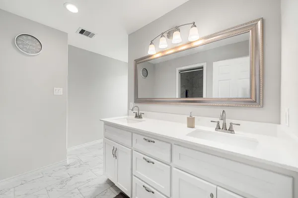 a bathroom with a double vanity sink and a mirror