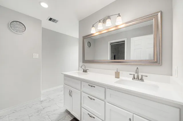 a bathroom with a double vanity sink and a mirror