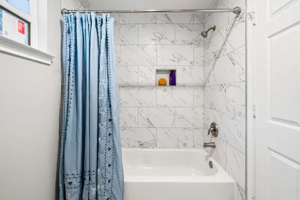 a bathroom with a bathtub and shower