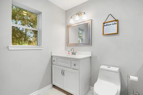 a bathroom with a toilet a sink and mirror