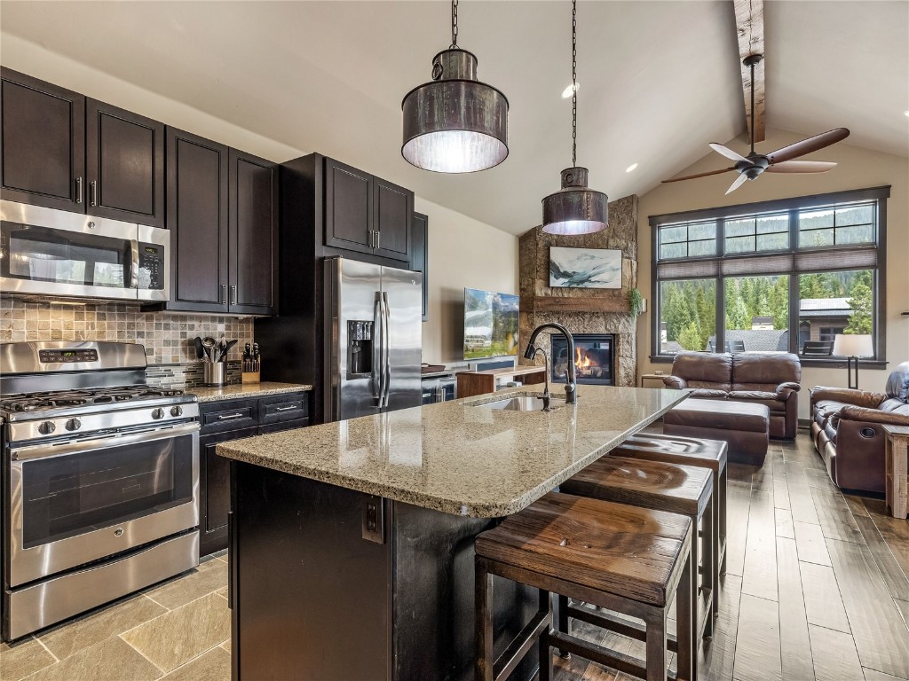 68 Independence Lane Keystone, CO 80435 - Photo 11 of 43 a kitchen with stainless steel appliances granite countertop a stove a sink dishwasher a dining table and chairs with wooden floor
