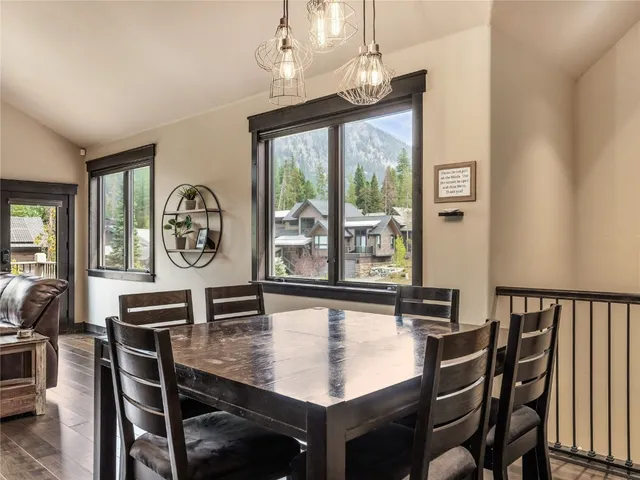 a kitchen with kitchen island a dining table chairs stainless steel appliances and cabinets
