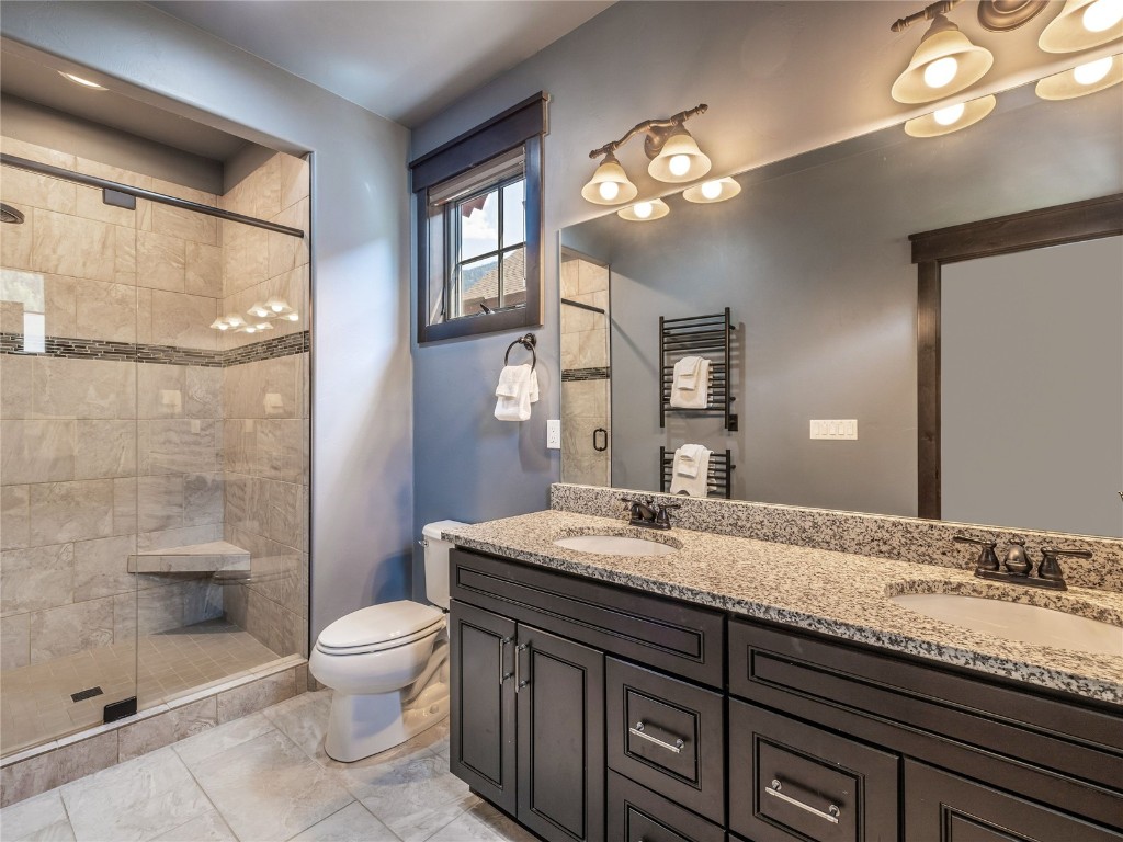 68 Independence Lane Keystone, CO 80435 - Photo 21 of 43 a bathroom with a granite countertop sink a toilet a mirror and shower