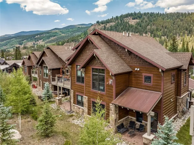 an aerial view of a house with swimming pool and mountains