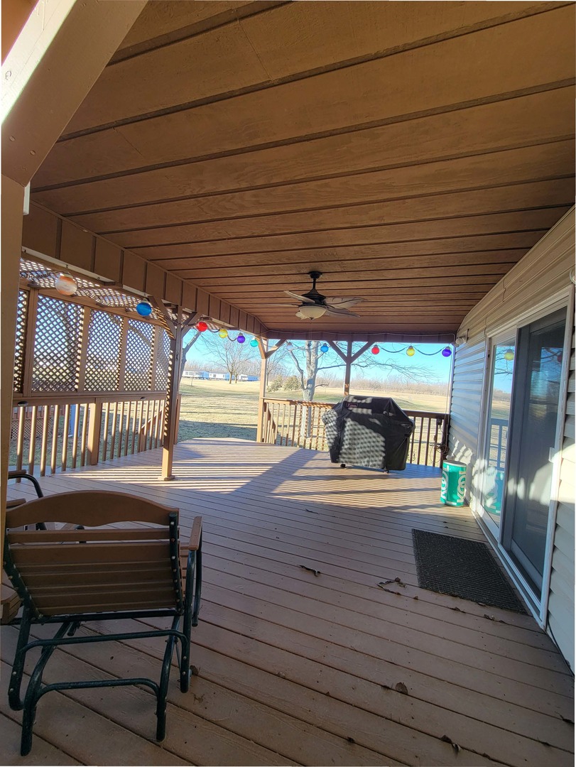 5016 West Colonial Drive, Unit 317 Monee, IL 60449 - Photo 17 of 32 a view of a patio with table and chairs with wooden floor and fence