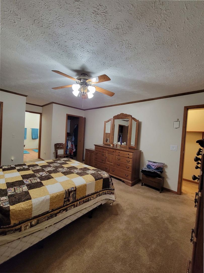 5016 West Colonial Drive, Unit 317 Monee, IL 60449 - Photo 7 of 32 a spacious bedroom with a bed and a chandelier