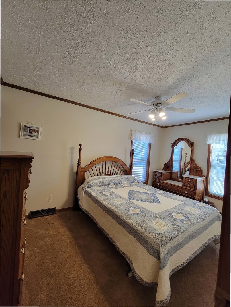 5016 West Colonial Drive, Unit 317 Monee, IL 60449 - Photo 10 of 32 a bedroom with a bed and a dresser
