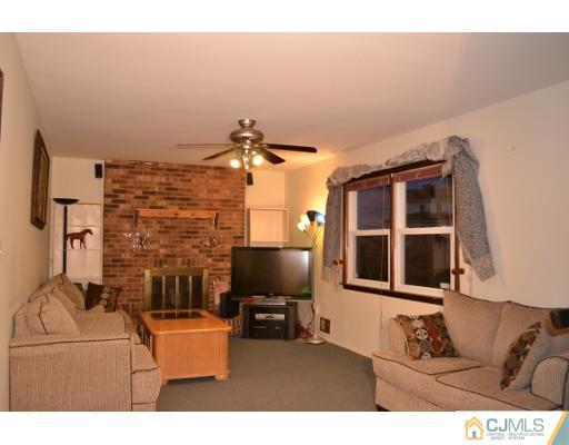 8 Roxy Avenue Edison, NJ 08820 - Photo 18 of 22 a living room with furniture and a flat screen tv