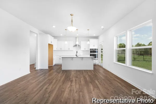 a view of kitchen with granite countertop window and stainless steel appliances
