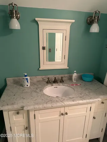 a bathroom with a granite countertop sink and a mirror