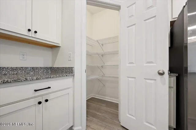 a bathroom with a granite countertop sink and white cabinets