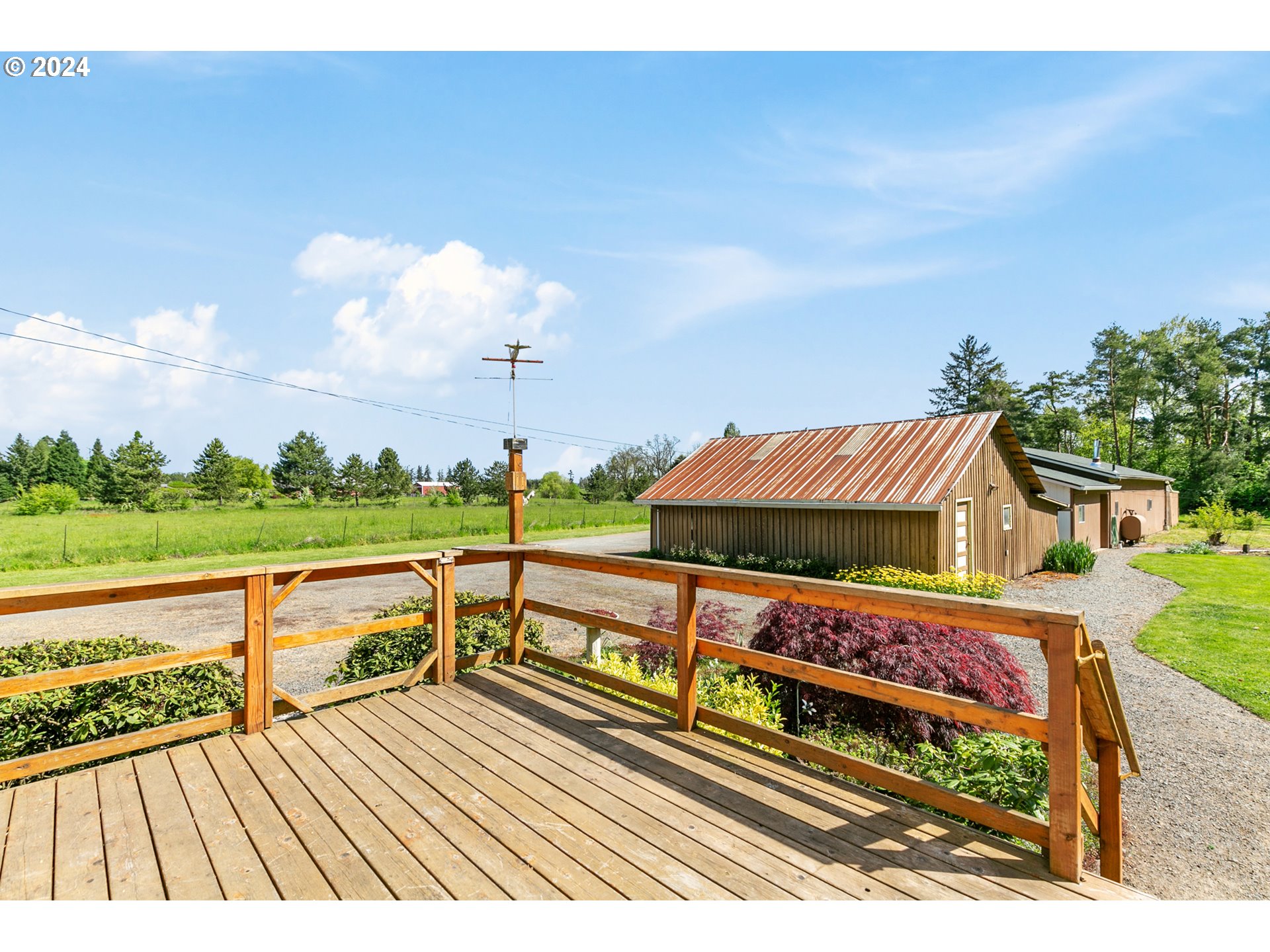 22778 Bents Road Northeast Aurora, OR 97002 - Photo 34 of 48 a view of a roof deck with table and chairs a barbeque with wooden floor and fence