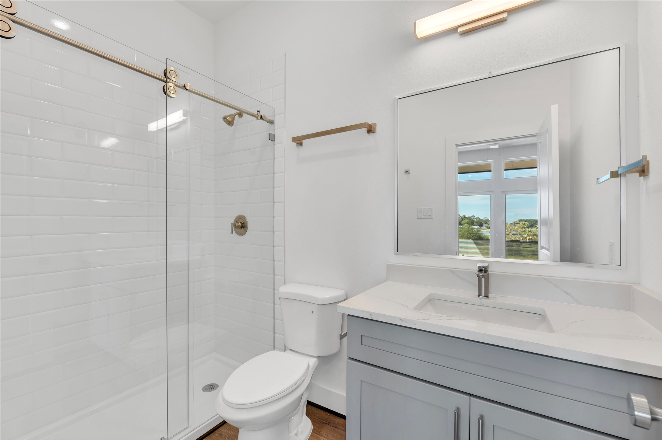119 Kirby Road, Unit 5205 Seabrook, TX 77586 - Photo 23 of 46 Bright bathroom featuring a sleek glass-enclosed shower with modern fixtures, a stylish vanity, and a large mirror reflecting natural light.
