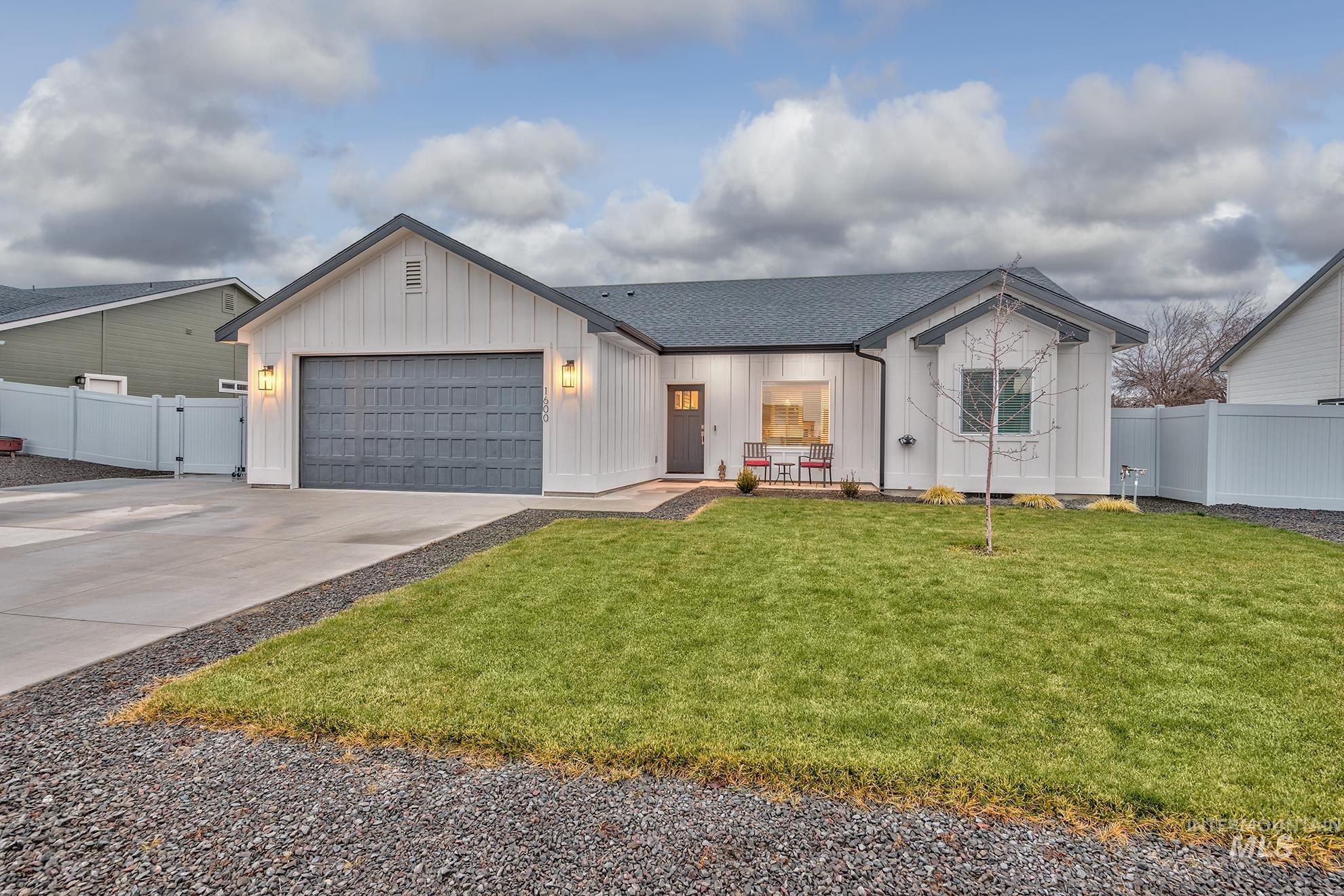 View of front of home with board and batten siding, driveway, a shingled roof, and an attached garage