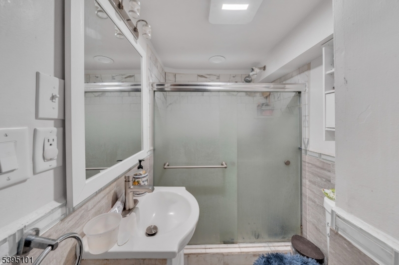 361 15th Avenue, Unit 3 Paterson, NJ 07504 - Photo 3 of 6 a bathroom with a sink a mirror and shower