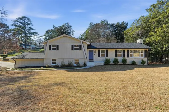 a front view of a house with yard and trees