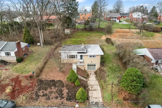 an aerial view of a house with garden space and street view