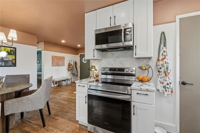a kitchen with stainless steel appliances a stove microwave and refrigerator