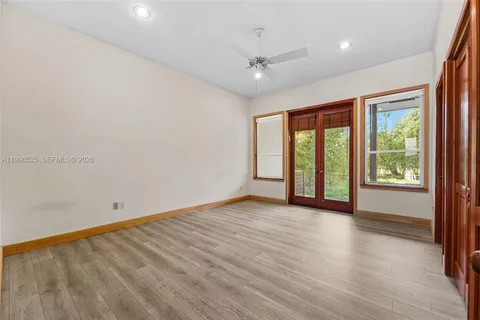 a living room with furniture a flat screen tv and floor to ceiling window
