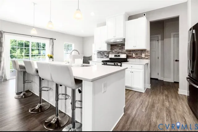 a kitchen with stainless steel appliances a stove a sink dishwasher and a refrigerator