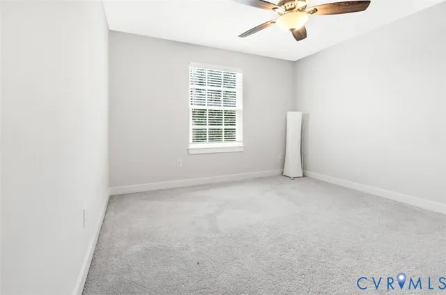 an empty room with a window and a ceiling fan