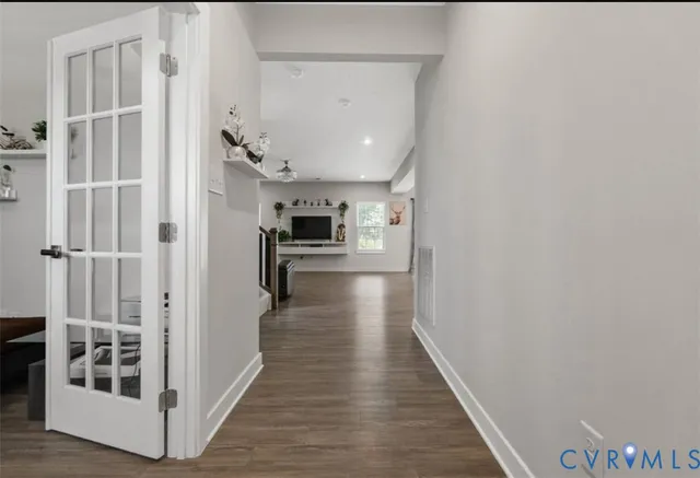 a view of a hallway with wooden floor and staircase