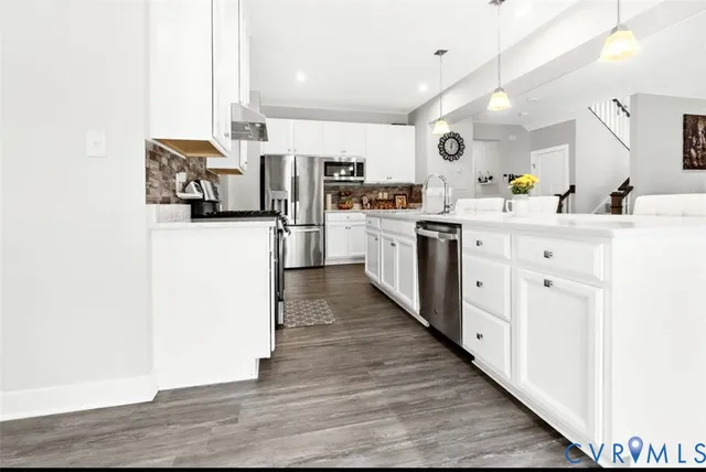 a kitchen with cabinets and wooden floor