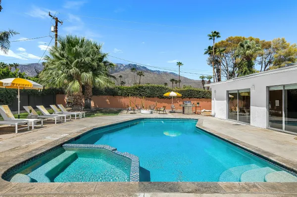a view of swimming pool with outdoor seating and plants